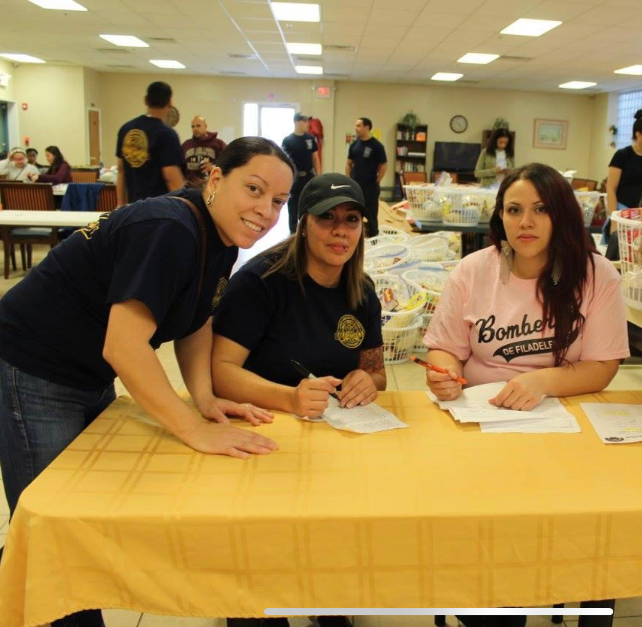Three SAPFA members signing in volunteers at a Thanksgiving Turkey basket assembly event
